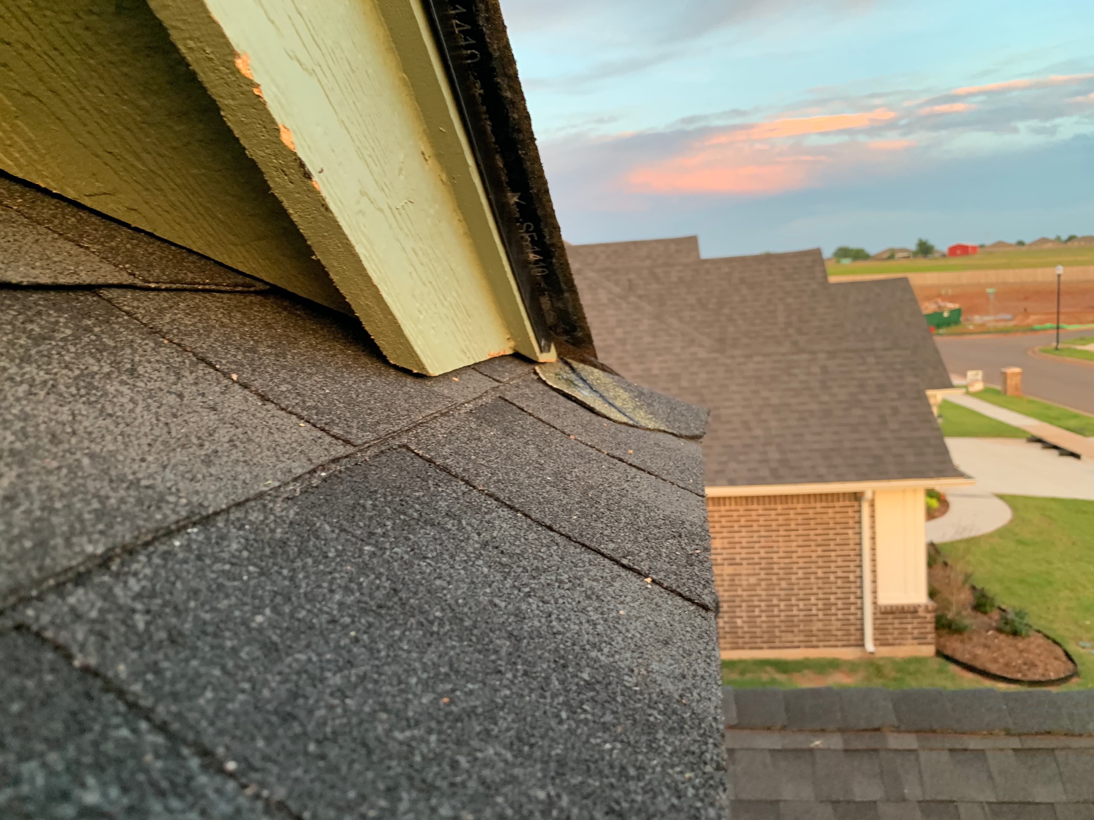Close-up inspection of roof rake edge, starter shingle alignment, and drip edge flashing on a Norman, OK home.