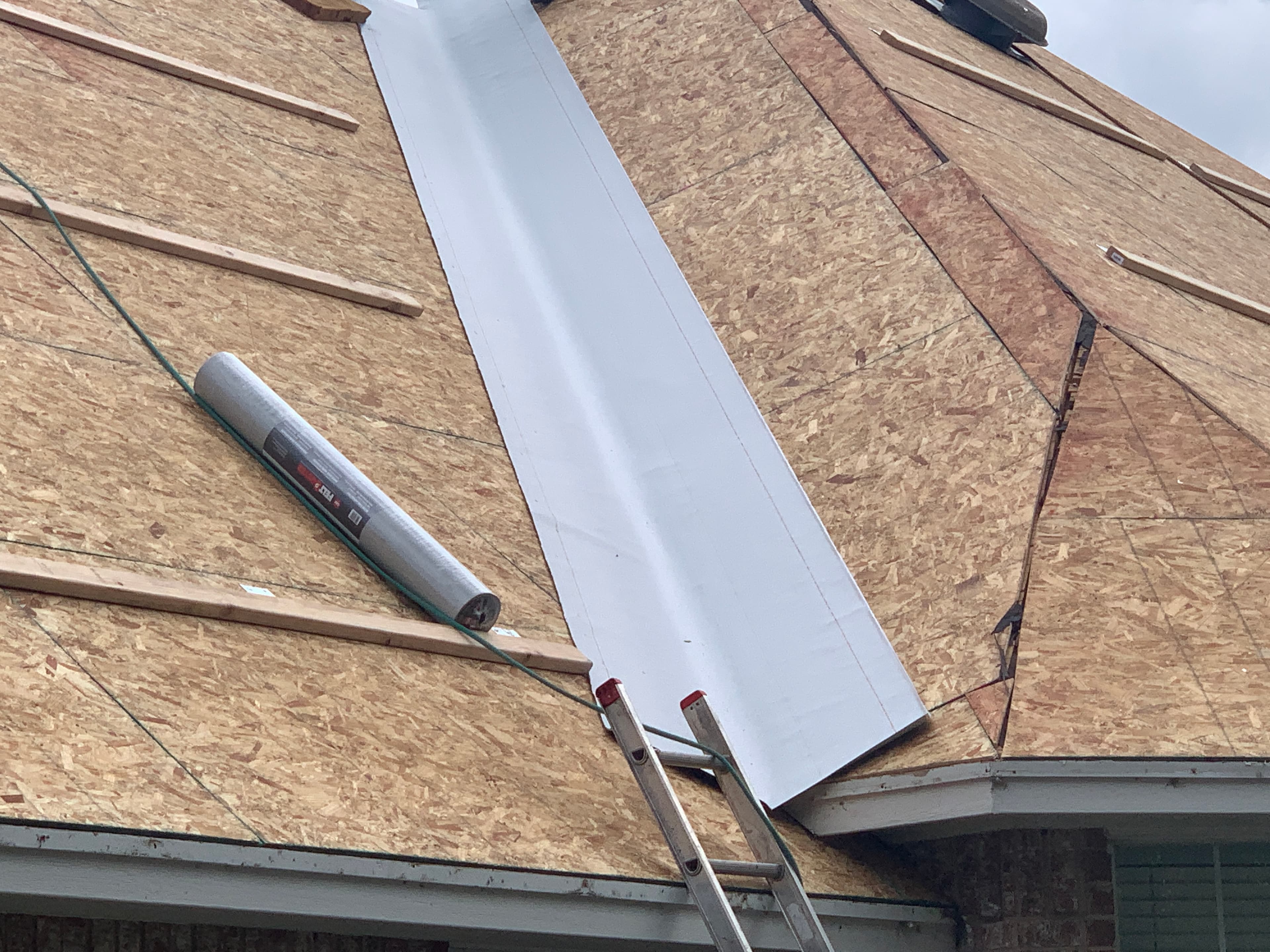 Exposed OSB roof decking prepped with leak-barrier valley underlayment prior to shingle installation in Oklahoma City.