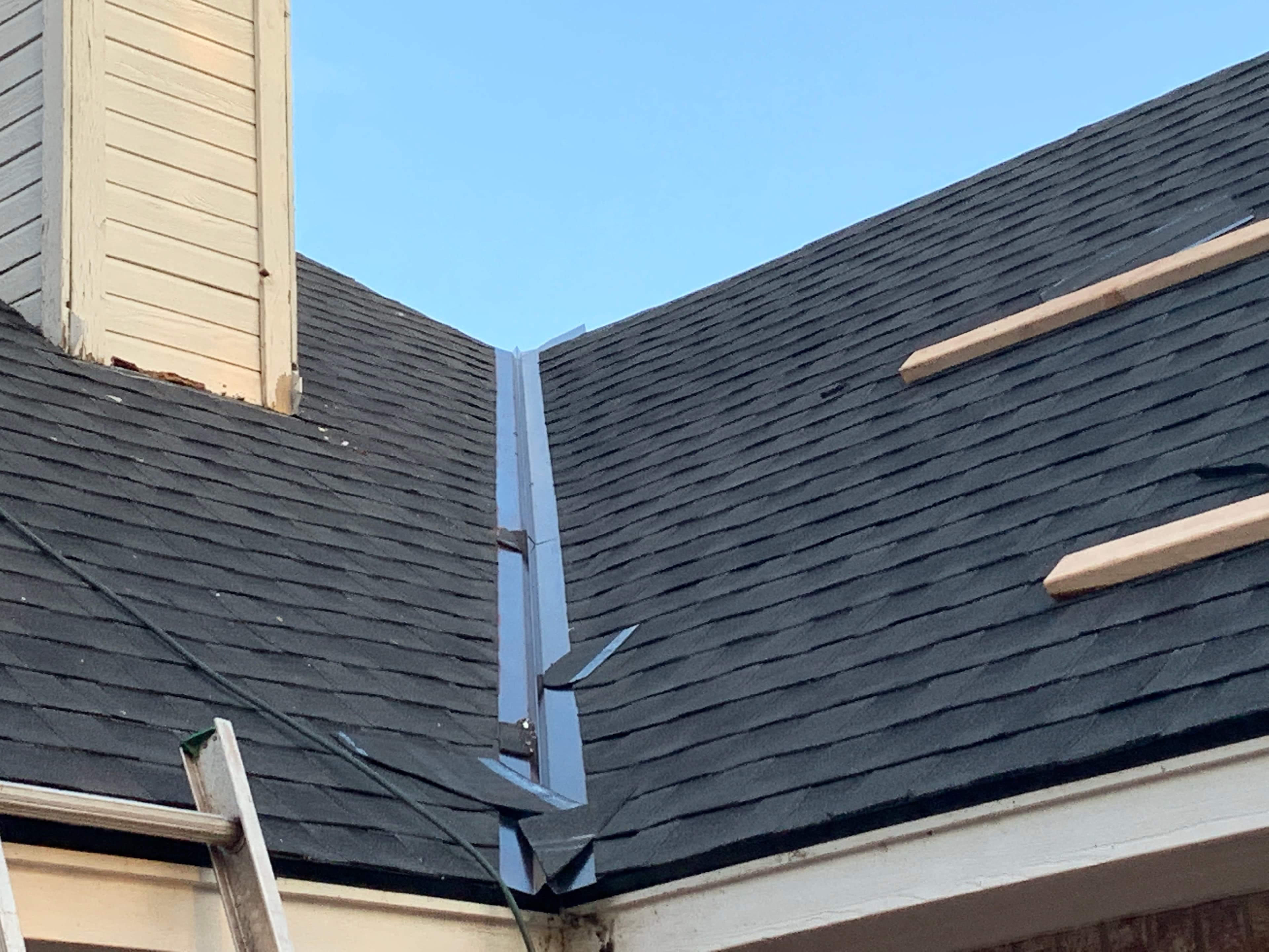Installation of a pre-formed metal W-valley flashing on a steep-slope shingle roof in Oklahoma City.